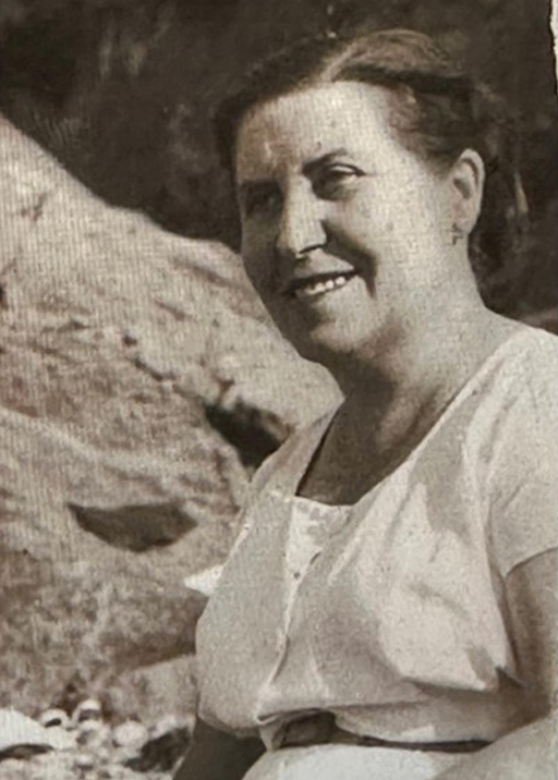 Mujer sonriente con indumentaria clara.