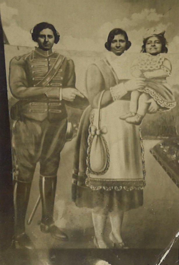 Tres mujeres delante de un recortable que representa una familia.