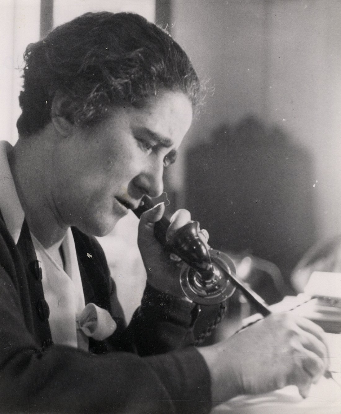 Retrato de mujer hablando por teléfono y escribiendo.