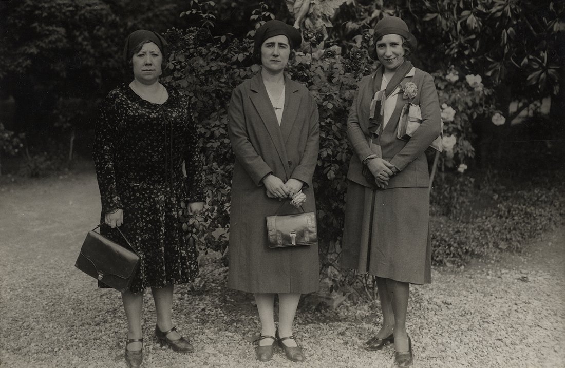 Tres mujeres en un jardín.