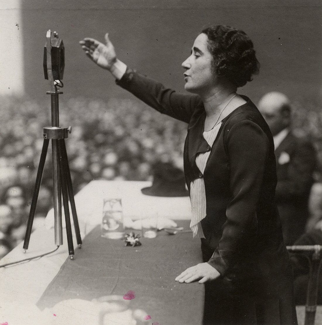 Mujer hablando a una multitud con un micrófono.