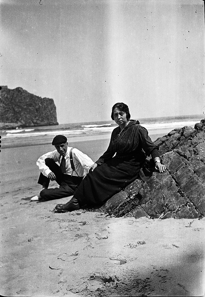 Mujer y hombre sentados en una playa.