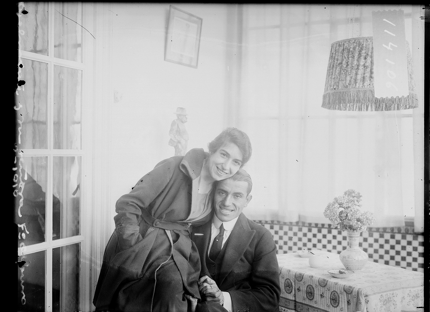 Mujer sentada encima de un hombre, con las cabezas juntas sonriendo, en un comedor