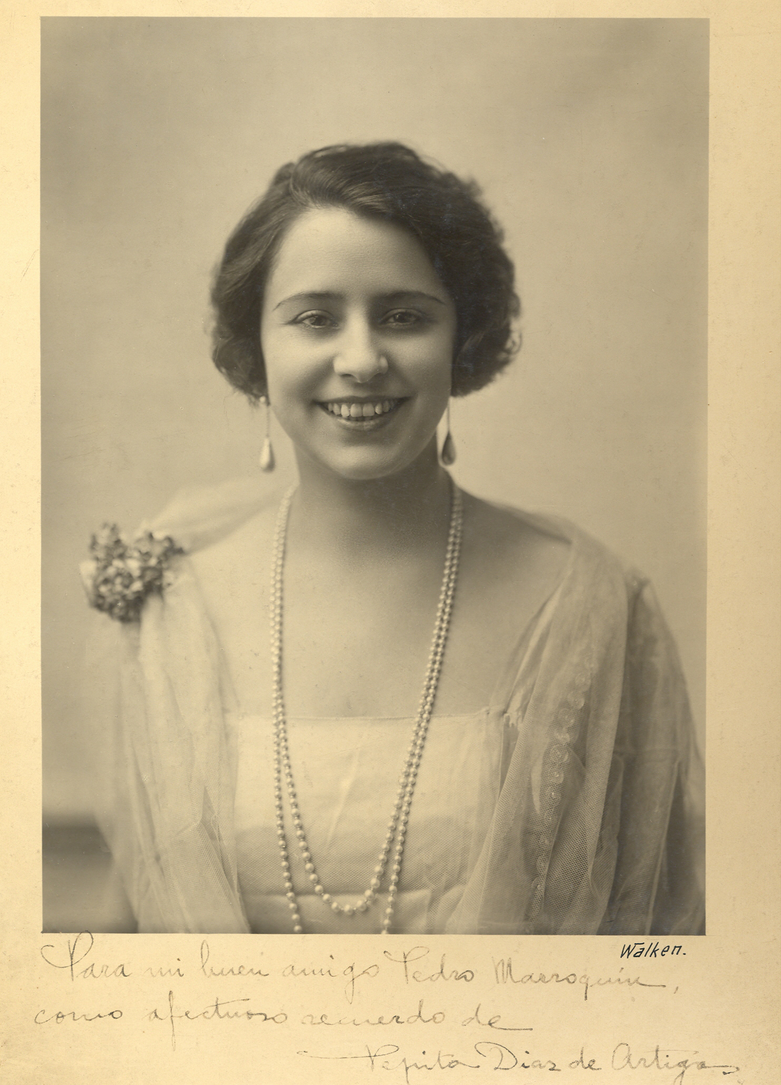 Retrato de mujer sonriente, con dedicatoria debajo.