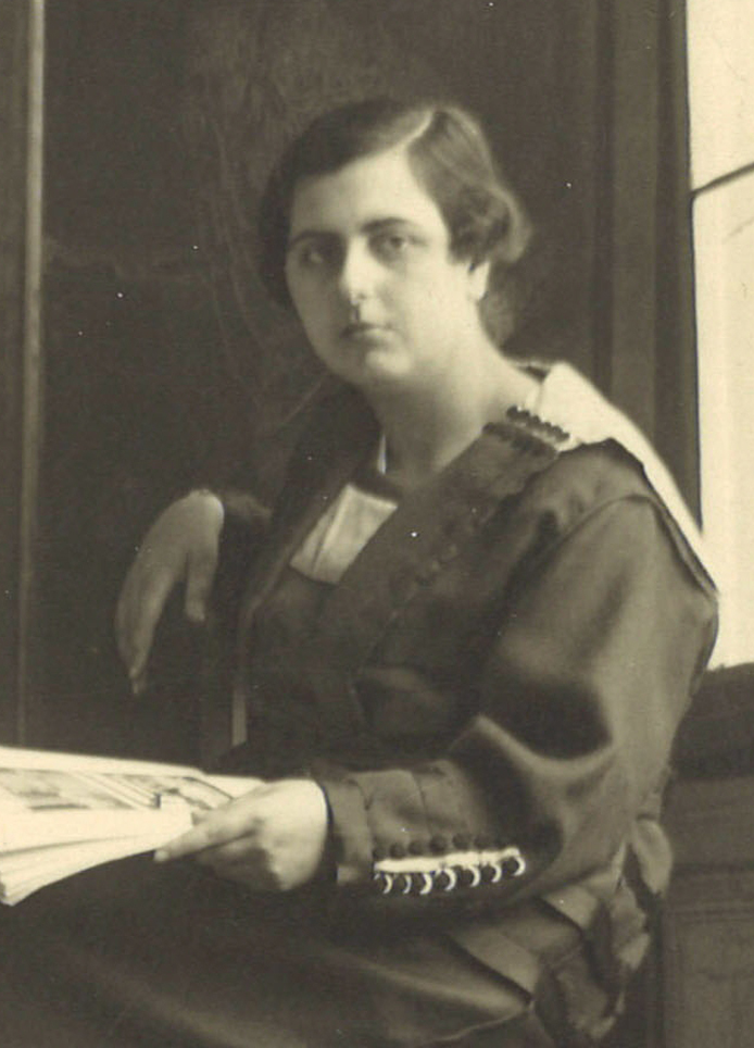 Retrato de mujer sentada con un libro en la mano.