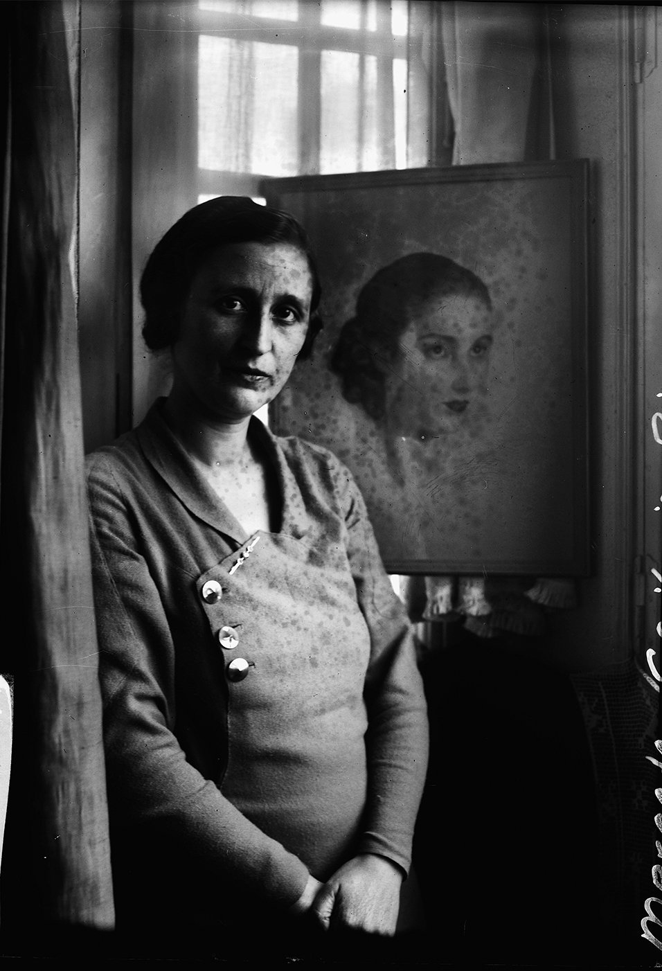 Mujer delante de un retrato suyo.