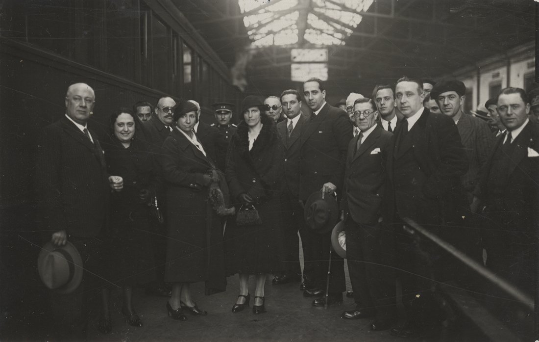 Grupo de mujeres y hombres en una estación de tren.