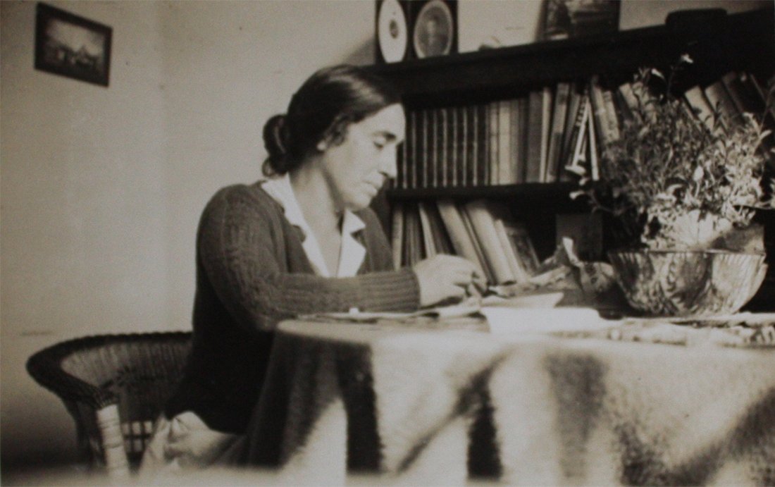 Mujer en una habitación escribiendo.