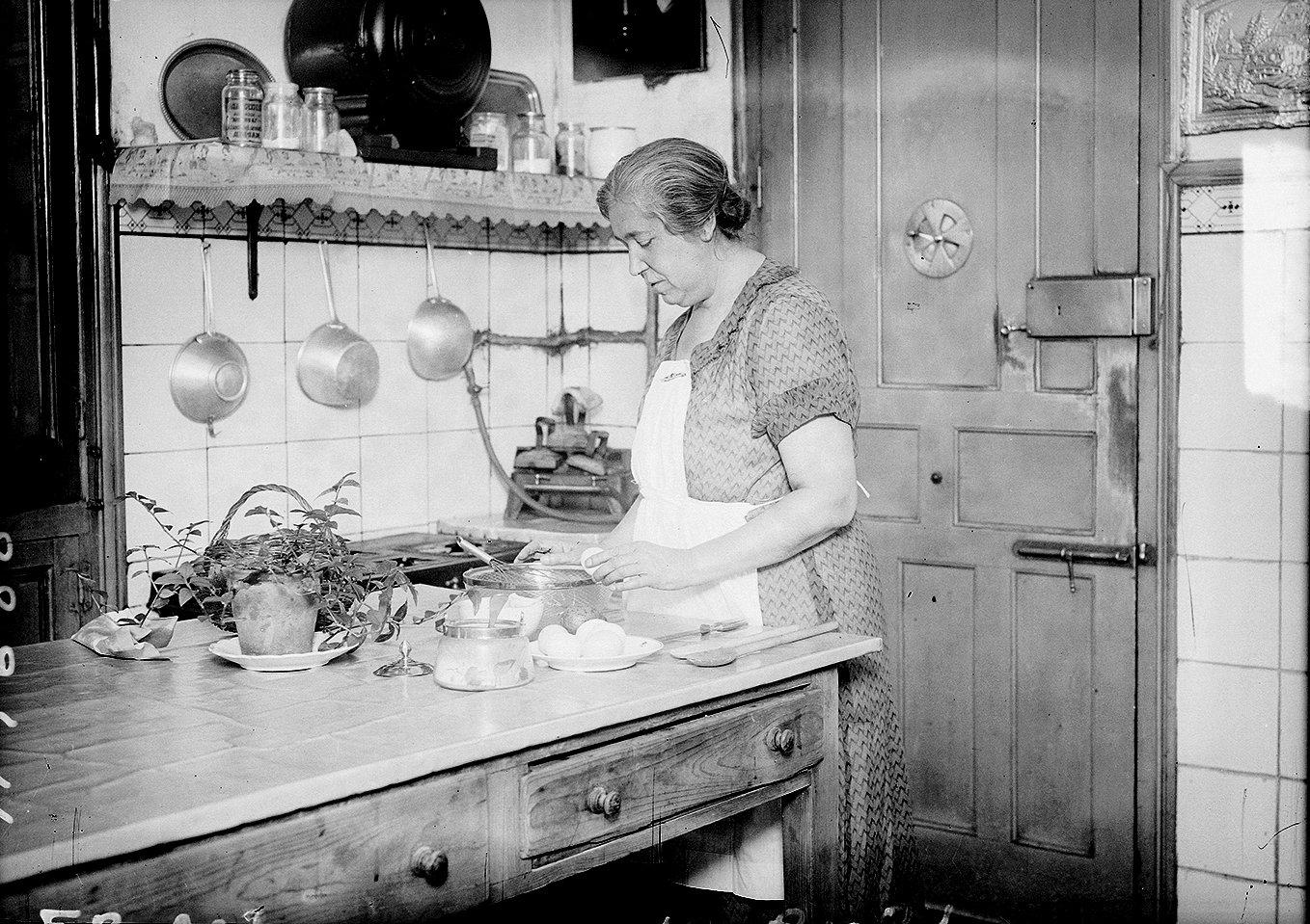 Mujer rompiendo un huevo en una cocina.