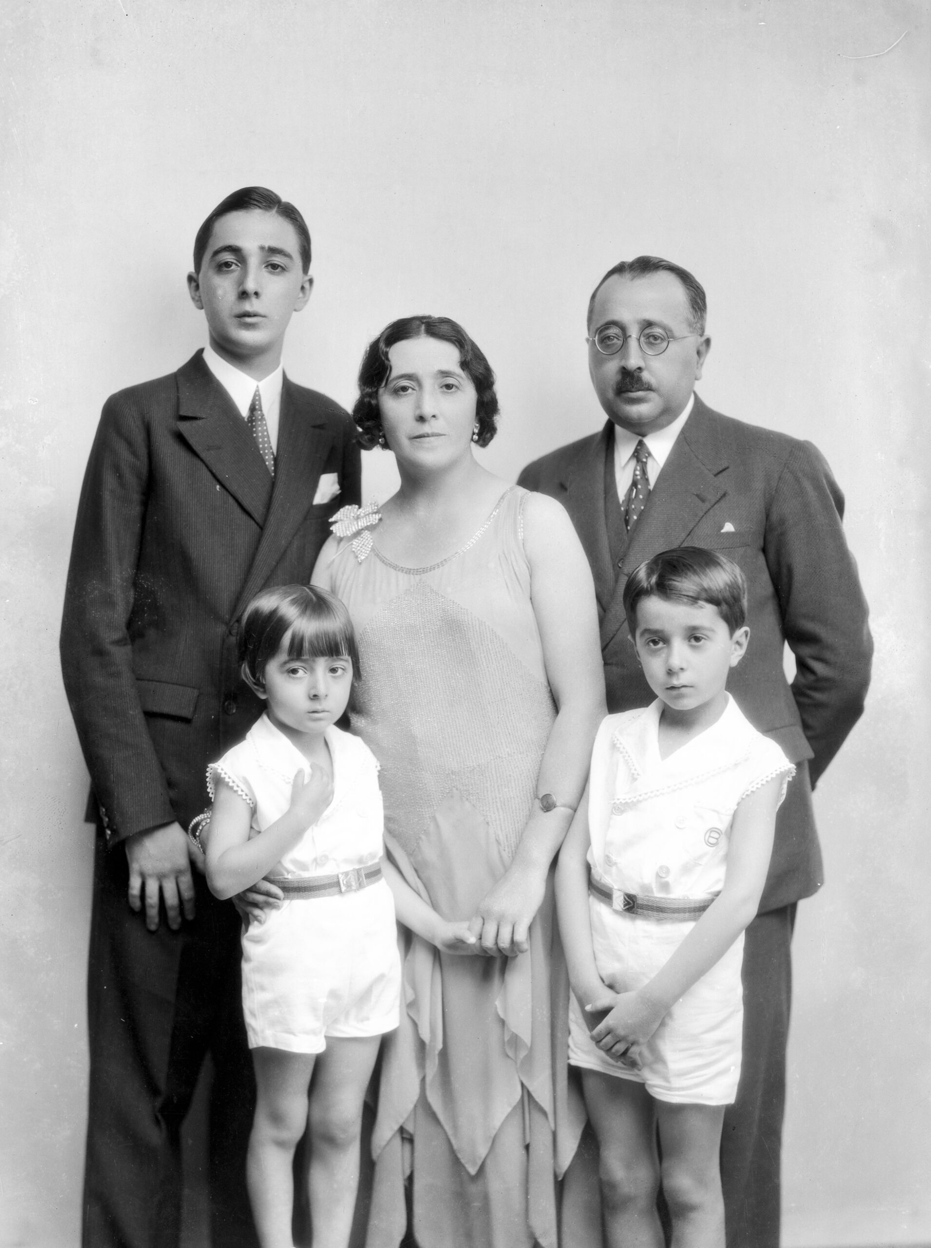 Retrato de familia, con un hombre, una mujer, un joven, un niño y una niña.