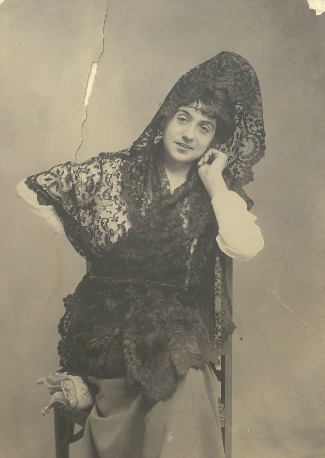 Mujer con mantilla y peineta, y la cabeza apoyada en la mano.