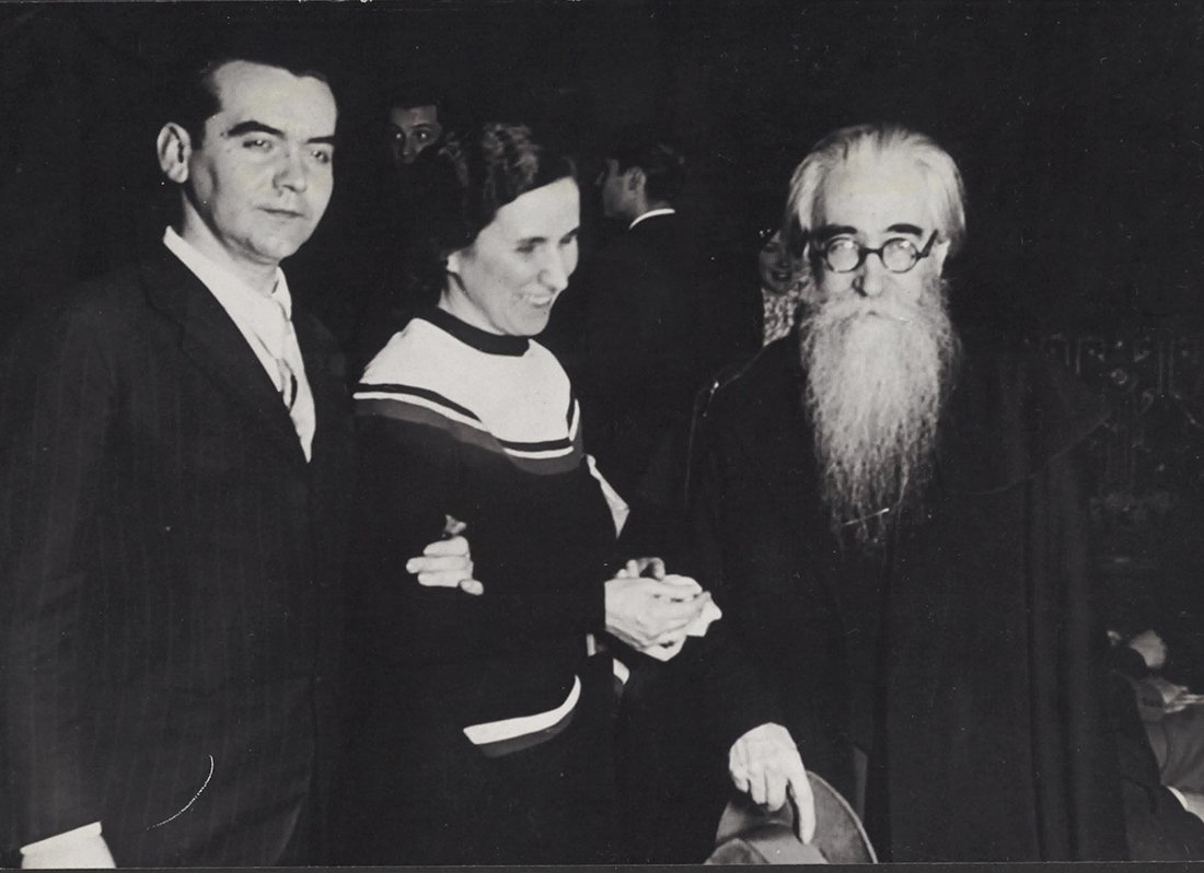 Dos hombres y una mujer cogidos de los brazos.