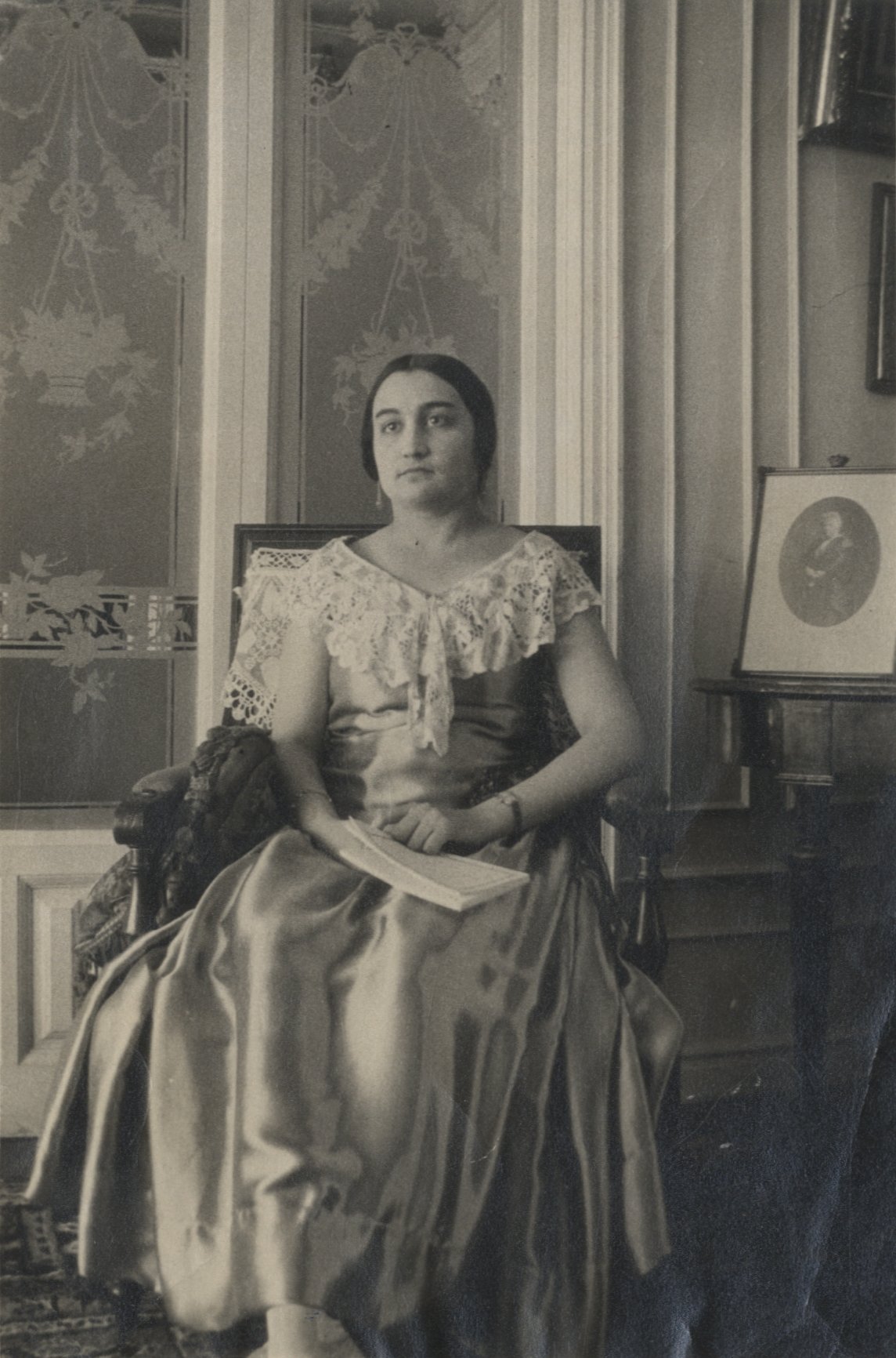 Mujer con vestido sentada en una silla.