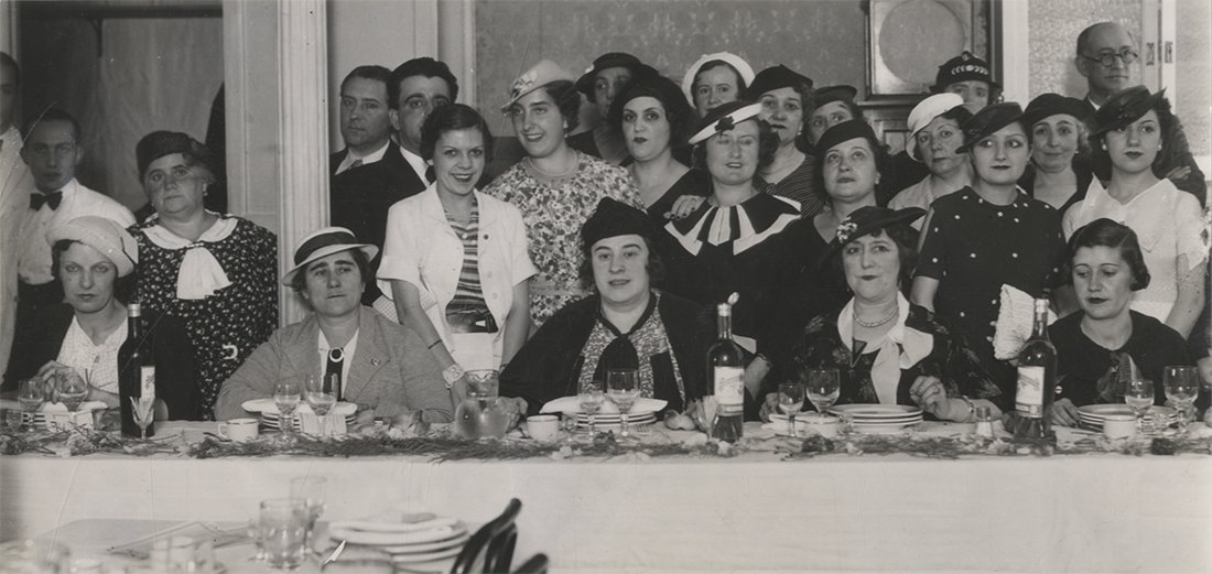 Grupo de mujeres delante de una mesa de comedor elegante.