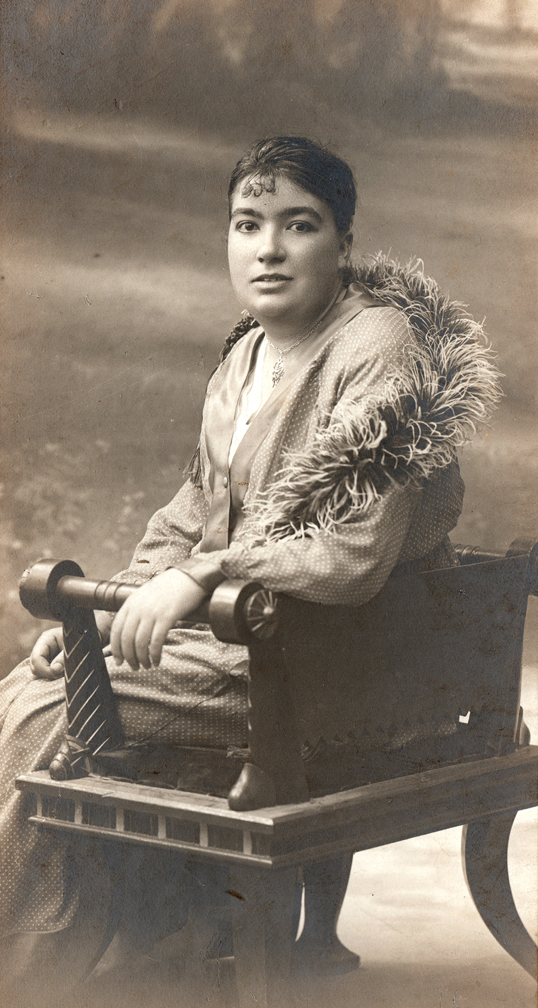 Retrato de mujer sentada en una banqueta.