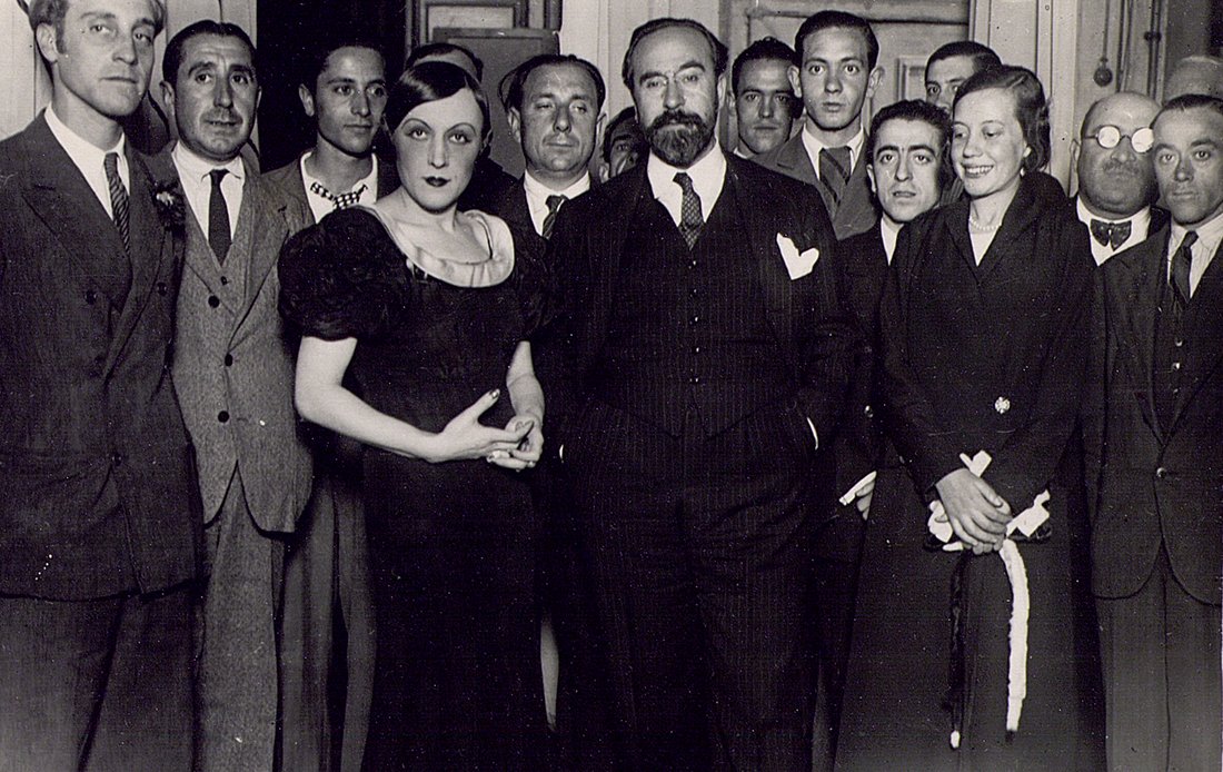 Grupo de hombres y dos mujeres posando.