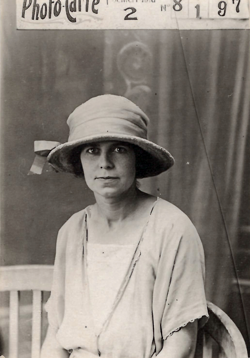 Mujer con sombrero sentada en un banco.